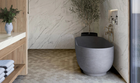 How can choosing tiles with a slight grip finish in bathrooms reduce slipping chances?