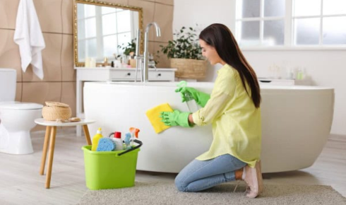 How can using a bucket to catch initial dirty water after tank cleaning protect bathroom floors?