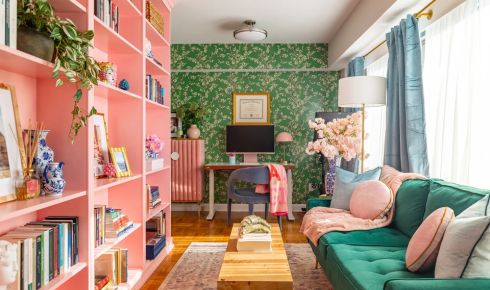 How can leaving one wall free of shelves or frames keep a room from feeling visually overloaded?